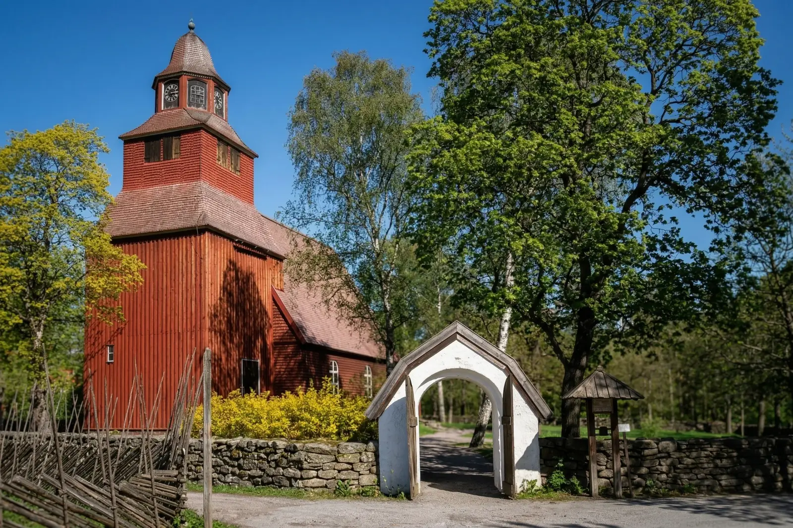 Église Seglora à Skansen avec sa porte blanche et son mur en pierre par une belle journée de printemps