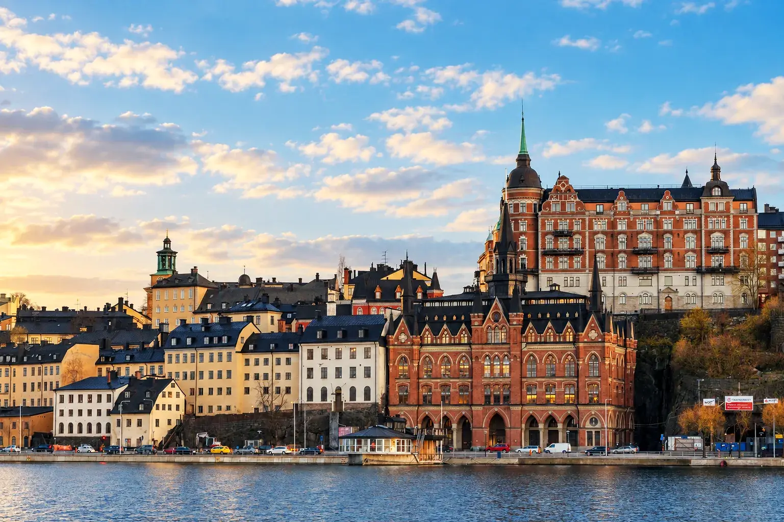 Panoramic Stockholm waterfront view from Monteliusvägen under a bright blue sky