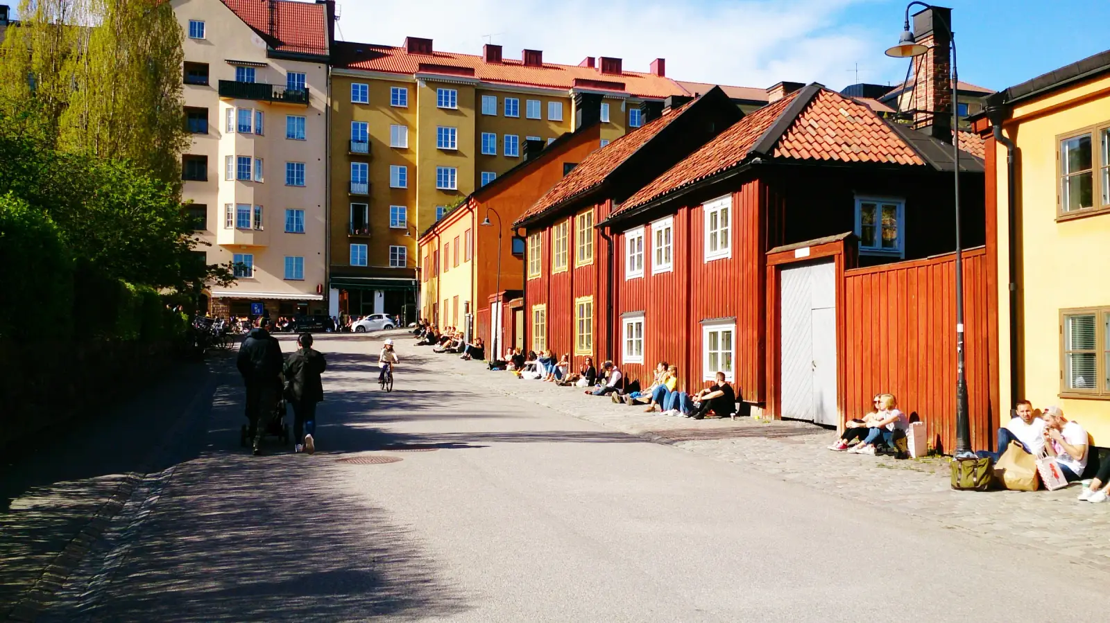 People relaxing beside colorful historic wooden houses near Nytorget in Södermalm